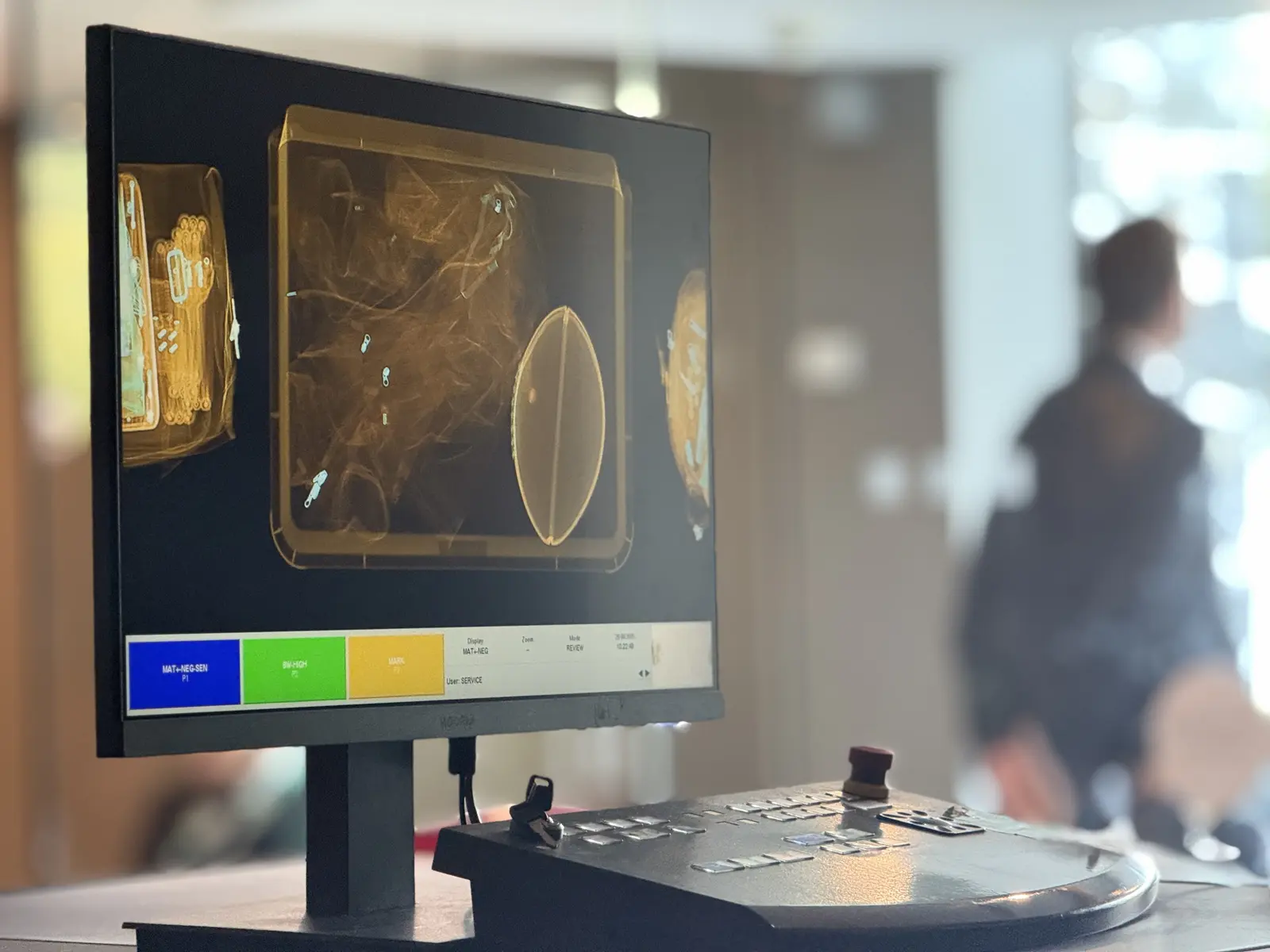X-ray operator console and screen showing a scanned bag during screening