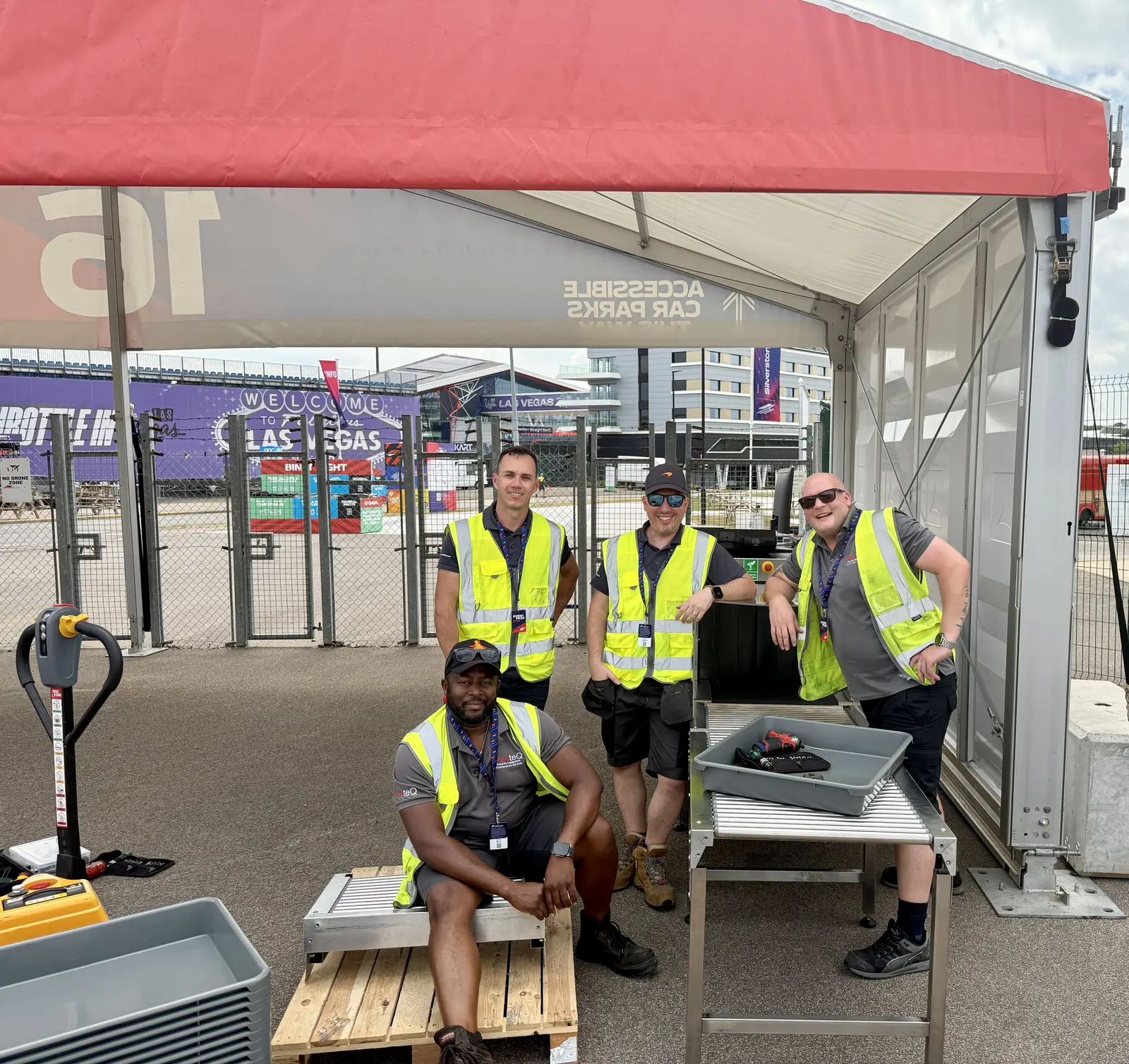 Four smiling RedteQ engineers at an event checkpoint deployment